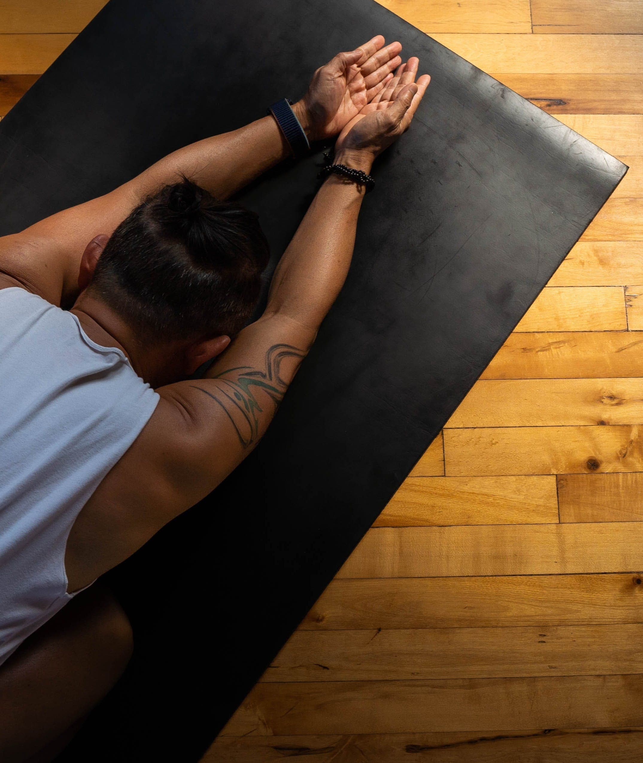David Cho in a stretch on his yoga mat