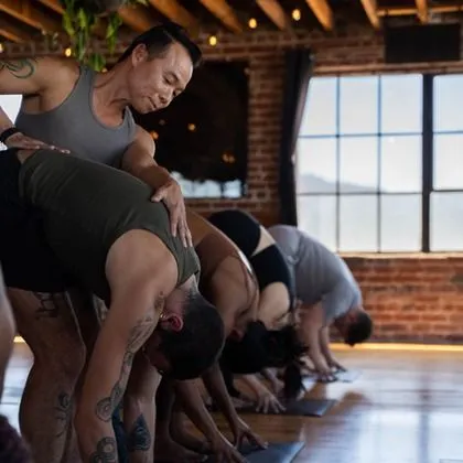 David Cho assisting a student during a Flow & Restore class at Haum Studios