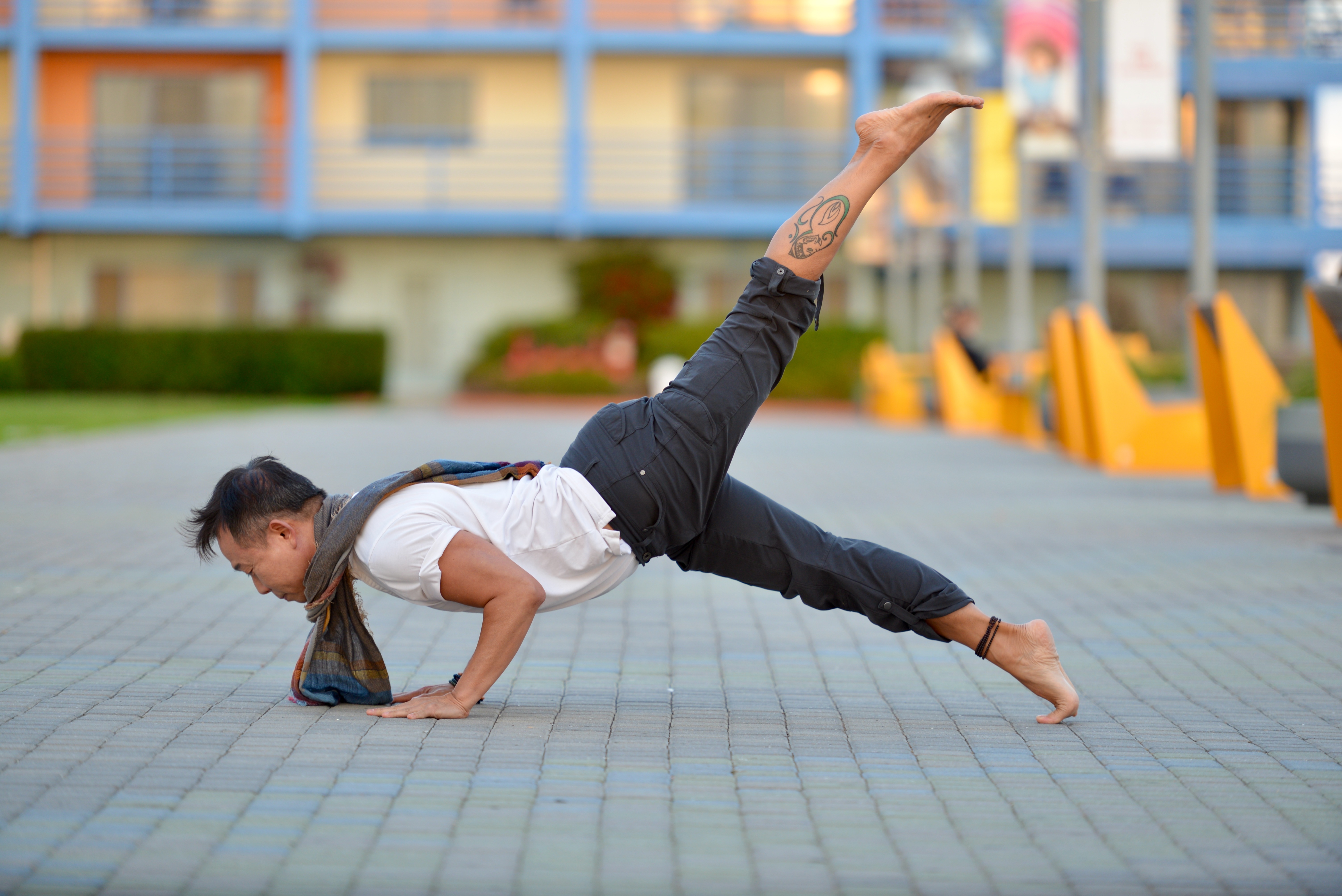 David Cho holding a one-arm plank with leg extended